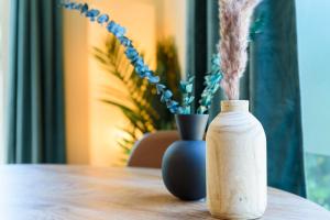 a wooden bottle on a table with a vase at Chalet met eigen tuin aan de Veluwse bosrand in Putten +20 photos