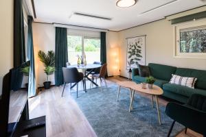 - un salon avec un canapé et une table dans l'établissement Chalet met eigen tuin aan de Veluwse bosrand, à Putten
