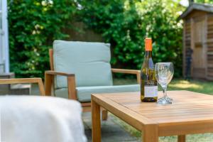 - une bouteille de vin assise sur une table avec un verre dans l'établissement Chalet met eigen tuin aan de Veluwse bosrand, à Putten