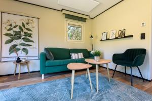 - un salon avec un canapé vert et 2 chaises dans l'établissement Chalet met eigen tuin aan de Veluwse bosrand, à Putten