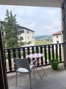 a table and a chair sitting on a balcony at Appartement cosy in Métabief