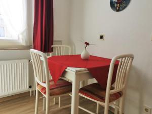 una mesa de comedor con un mantel rojo. en Kleines Logierhaus 03, en Norderney