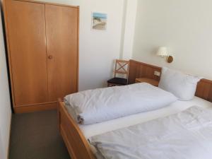 1 dormitorio con 2 camas y armario en Kleines Logierhaus 03, en Norderney