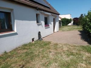 una casa blanca con un patio al lado de un edificio en Gite maison de campagne en Boissey-le-Châtel