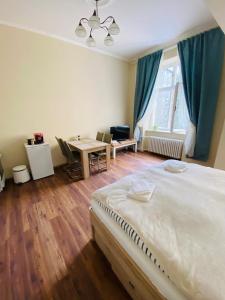 a bedroom with a bed and a desk and a table at Apartmán Diana in Karlovy Vary