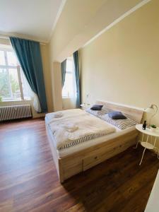ein Schlafzimmer mit einem großen Bett und Holzboden in der Unterkunft Apartmán Diana in Karlsbad