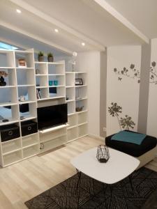 a living room with white shelves and a table at House Anita in Krk