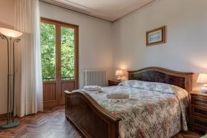 a bedroom with a bed and two lamps and a window at Gigli di Firenze in Rufina