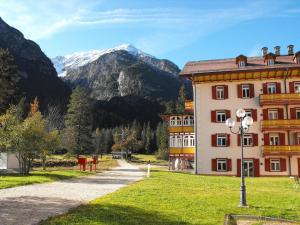 a building in a field with mountains in the background at loft panorama Tre cime Dobbiaco Cortina in Dobbiaco