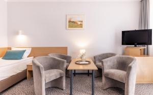 ソリナにあるHotel Solina Resort & Spaのベッド、テーブル、椅子が備わるホテルルームです。