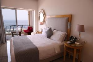 Una cama o camas en una habitación de Riviera Hotel and Beach Lounge, Beirut