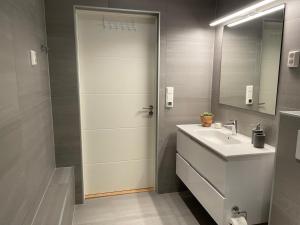 a bathroom with a shower and a sink and a mirror at Apartments Bergen with sea view! in Bergen