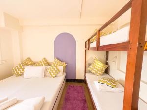 una camera con 2 letti a castello e un soffitto viola di Locomo Mumbai - Stay Work Eat a Mumbai