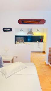 a bedroom with a white bed and a table in it at Casa Nena Es Calo in Es Caló