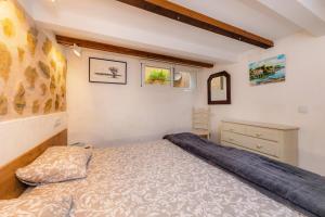 - une petite chambre avec un lit et une commode dans l'établissement Cel Pins, à Portopetro