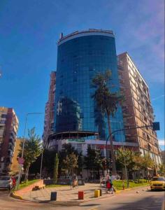 a tall glass building in front of a street at Center of Tirana - Apartment in Tirana