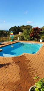 a swimming pool with blue water on a brick patio at SeeBos Holiday Home in Port Edward