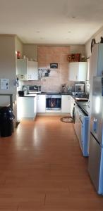 a kitchen with white appliances and a wooden floor at SeeBos Holiday Home in Port Edward