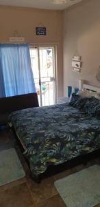 a bedroom with a bed with a blue comforter at SeeBos Holiday Home in Port Edward