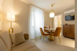 a living room with a couch and a table with chairs at Casa Carmela Apartments in Bardolino