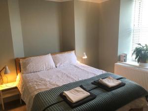 a bedroom with a bed with two towels on it at The Nest, Central Falmouth, 10 mins to the beaches and off street parking in Falmouth