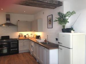 a kitchen with a white refrigerator and a sink at The Nest, Central Falmouth, 10 mins to the beaches and off street parking in Falmouth