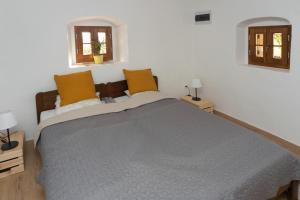 1 dormitorio con 1 cama grande y 2 ventanas en Tagyon Birtok Hordó Apartman en Tagyon
