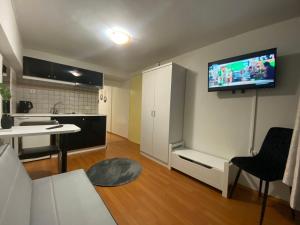 a living room with a kitchen and a tv on the wall at Le.Chris Central Dorms in Rethymno Town