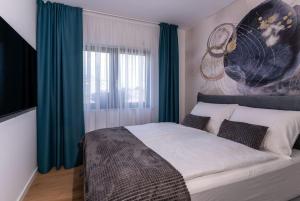 a bedroom with a large bed with blue curtains at Capsula Luxury Apartment Umag in Umag