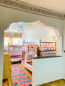- une chambre avec 4 lits superposés et un tapis dans l'établissement Azoul Surf Hostel Taghazout, à Taghazout