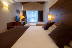 Rúm í herbergi á Hotel Màgic La Massana