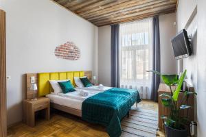 een slaapkamer met een bed en een tv erin bij Aparthotel Pergamin in Krakau
