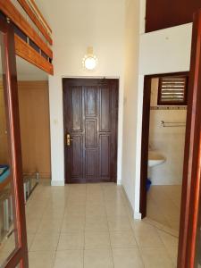 a hallway with a wooden door and a sink at Vila Familija in Dobra Voda