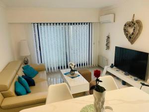 a living room with a couch and a table at Appart vue mer avec piscine in Saint-Raphaël