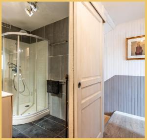 La salle de bains est pourvue d'une douche et d'une porte en verre. dans l'établissement Maison de village T4 3 chambres avec parking gratuit Monnetier-Mornex, à Monnetier-Mornex