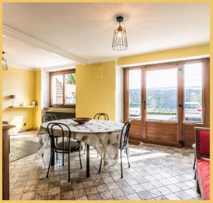 - une salle à manger avec une table et des chaises dans l'établissement Maison de village T4 3 chambres avec parking gratuit Monnetier-Mornex, à Monnetier-Mornex