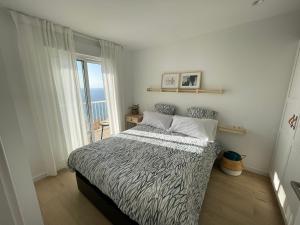een slaapkamer met een bed en een groot raam bij Apartamento turístico Playmon Bacana Planta 14 in Benidorm