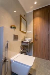 a bathroom with a toilet and a sink and a mirror at Villa Amara 29 by Stay ALYF, Lonavala in Lonavala