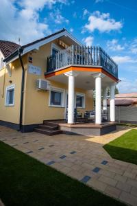 a house with a balcony and a patio at LuxVil Apartman in Balatonkeresztúr