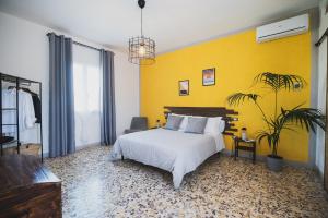 a bedroom with a white bed and a yellow wall at Nonna Gina Country House in San Miniato Basso