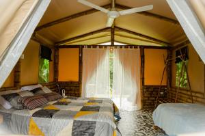 a bedroom with a bed and a ceiling fan at Aguas Claras Bamboo Glamping in Guaduas