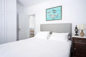 - une chambre avec un lit blanc et une photo sur le mur dans l'établissement Villa Oinos - Sunset Views, à Órmos Athiniós