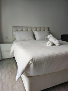 a large bed with white sheets and pillows at One Bukit Ceylon KLCC in Kuala Lumpur