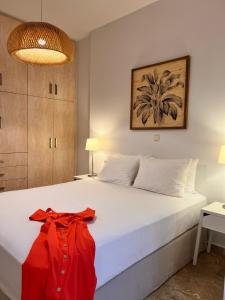 a bedroom with a white bed with a red shirt on it at Stella in the Village Studio Sea View in Plakias