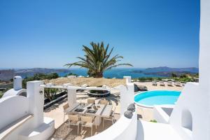 - une vue sur un complexe avec une piscine et un palmier dans l'établissement Villa Oinos - Sunset Views, à Órmos Athiniós