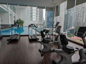 einen Fitnessraum mit Kardiogeräten in einem großen Gebäude in der Unterkunft One Bukit Ceylon KLCC in Kuala Lumpur