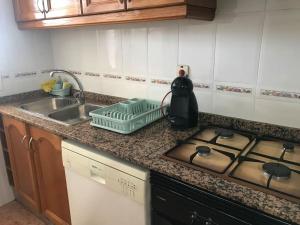 blat kuchenny ze zlewem i kuchenką w obiekcie Apartamento cómodo y espacioso con parking w Walencji