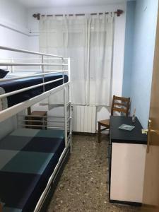 Pokój z 2 łóżkami piętrowymi, stołem i biurkiem w obiekcie Apartamento cómodo y espacioso con parking w Walencji