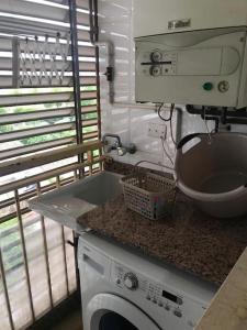 a kitchen with a washing machine and a sink at Apartamento cómodo y espacioso con parking in Valencia