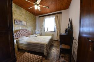 - une chambre avec un lit et un ventilateur de plafond dans l'établissement Jeannet's Beach House, à Amarinthos